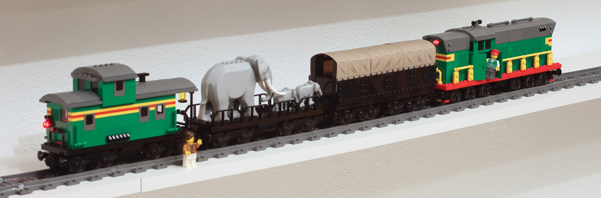 train Lego avec wagon bâché, éléphants et caboose.